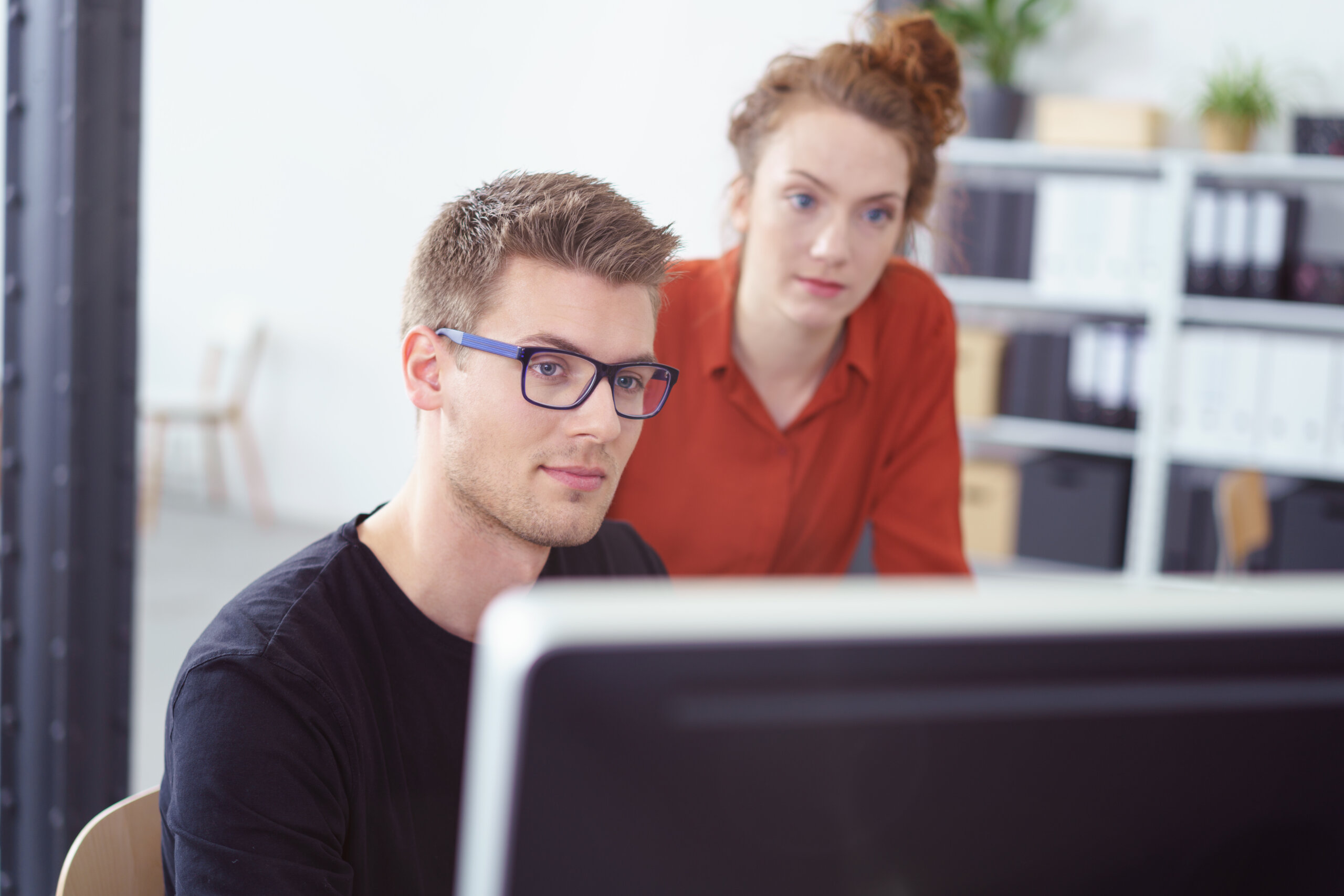 zwei Personen schauen auf einen Bildschirm